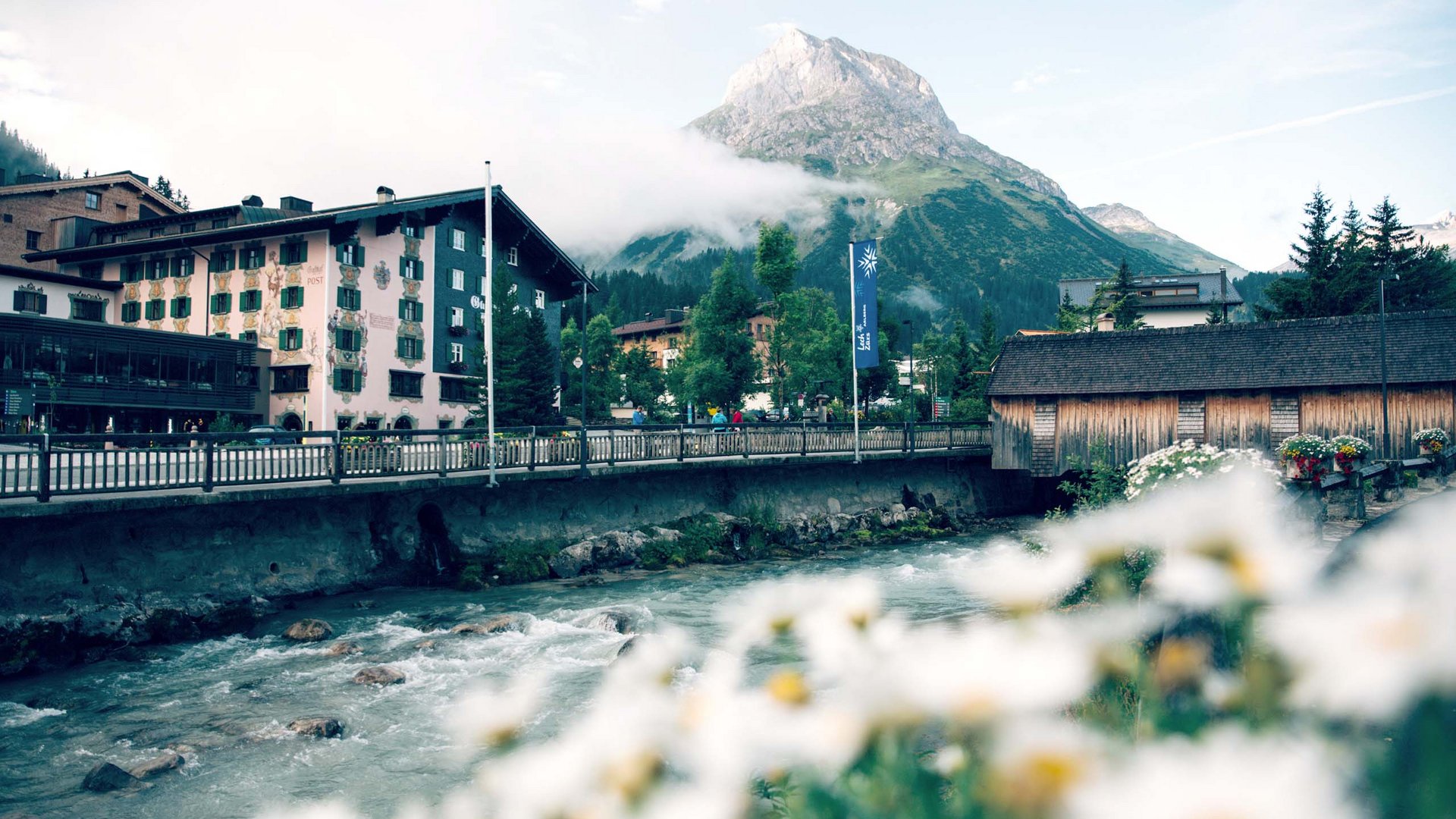 Sights in and around Lech am Arlberg Mountain village with flowers in foreground and mountain with clouds in background