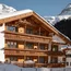 Holz Chalet im Schnee vor verschneiten Bergen und klarem Himmel